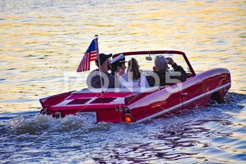 People enjoying ride in red amphibious car Stock Photos