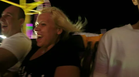People enjoying roller coaster ride at night Stock Footage