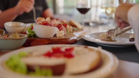 People Enjoying Shared Meal and Wine at Restaurant Table Stockbeeldmateriaal 336070512