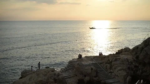 People enjoying sunset at sea while boat passing by them in Rovinj Croatia Stock-Footage 76801024
