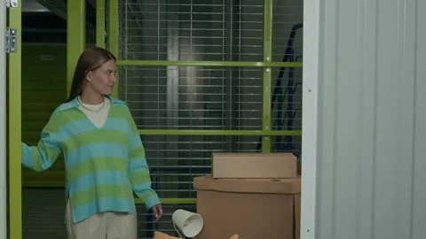 People Entering Storage Unit for Leaving Boxes during Moving Process Stock Footage 290779493