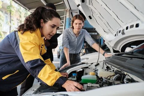 People with EV car engine fix claim and battery warranty ay g garage. Stock Photos