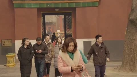 People Exiting Lama Temple Gate in Beijing with Phones and Historic Architecture Stock Footage 345684451