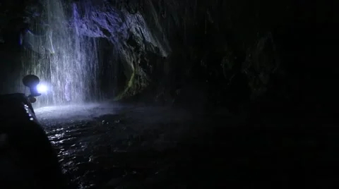 People exploring the waterfall in a deep cave Stock Footage 51633844