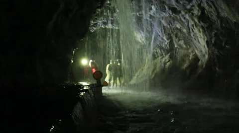 People exploring the waterfall in a deep cave Stock Footage 51709694