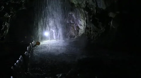 People exploring the waterfall in a deep cave Stock Footage 51797998