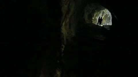 People exploring the waterfall in a deep cave Stock Footage 53250295