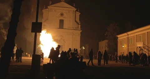 People facing a huge bonfire fire in the church square Stock Footage 100851124