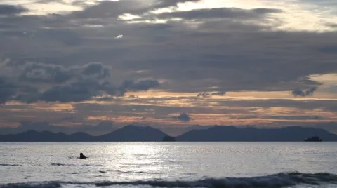 People floating around in the sea at sunset Stock Footage 56836615