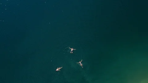 People floating on backs in the middle of a mountin lake Stock Footage 124265844