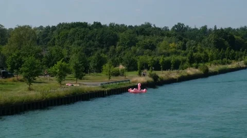 People floating on the water on a big inflatable pink flamingo. Stock Footage 211405019