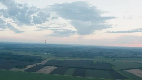 People flying paraglider under expansive evening sky Stock Footage 317178563