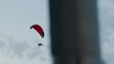 People flying powered paraglider under pastel sky Stock Footage 317149275