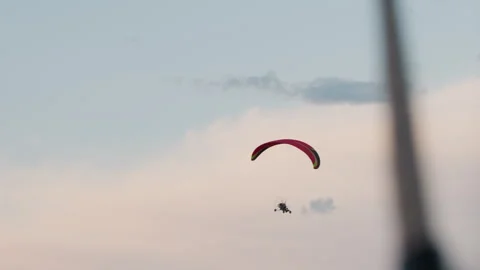 People flying powered paraglider under soft pastel sky Stock Footage 317161942
