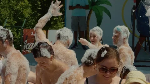 People in foam dancing at a foam show at a Aqua Park pool. Stock Footage 299920869