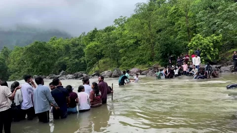 People forming human chain crossing strong current river during monsoon flood Stock Footage 340251802