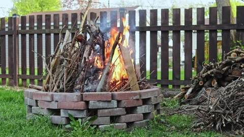 People gather around a fire in a backyard during the evening to socialise and Stock Footage 337867107