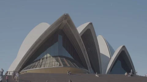 People Gathering on Steps Outside Sydney Opera House Under Clear Blue Sky Stock Footage 345718615