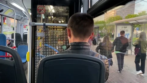 People get off bus at bus stop. Passengers sit inside public transport. City Stock Footage 196203206