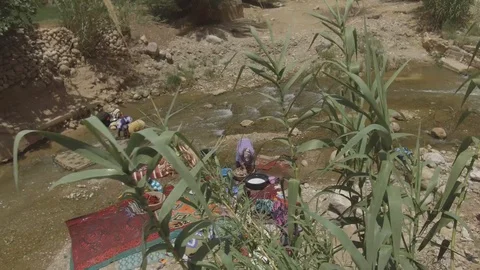 People get refreshed near a river in Maroccan valley, Africa in 4K establishing Stock Footage 92053053