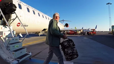 People getting off airplane after arrival at airport 動画素材 90368373
