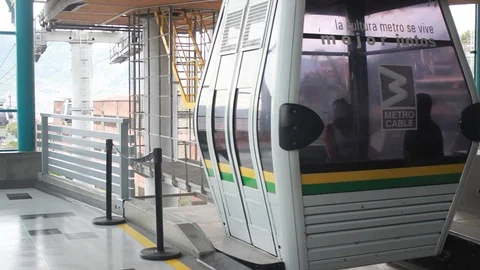 People getting out of a metrocable cabin when arriving at Santo Domingo station Stock Footage 91555686