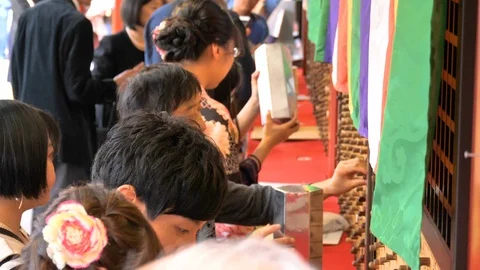 The people getting papers on the box in Senso-ji Temple in Tokyo Japan Stock Footage 121386939
