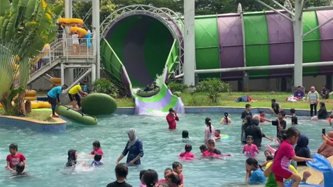 People going out from big water slide at local pool Stock Footage 255696147