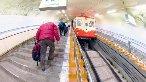 People going up to the stairs going inside the cable train in Japan Stock Footage 129276494