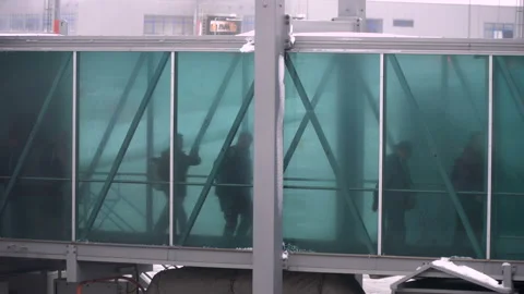 People going through jet bridge from plane to the airport. Stock Footage 103396019