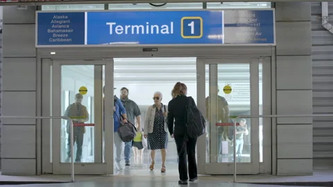 People going through parking lot doors at FLL terminal 1. Scene at Fort Lau.. Stock-Footage 331738723