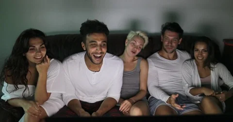 People Group Sitting On Couch Watching TV Program Talking, Young Cheerful Stock Footage 75835670