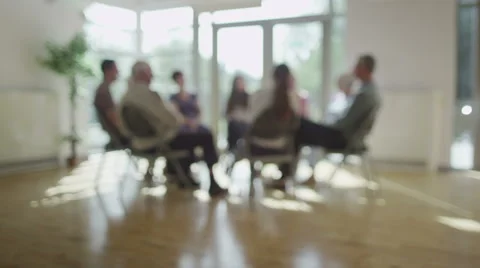 People in group therapy session talk about their problems in sunlit room Stock Footage 44684238