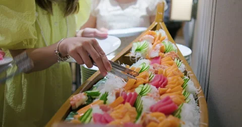 People hand grab buffet sashimi japanese food in hotel restaurant Stock Footage 252014451