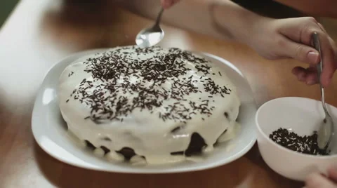 People hands with spoons are putting chocolate on the top of a cake. Stock Footage 63022954