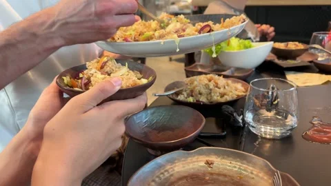 People hands using metal tongs serving fried rice, grilling on hot metal pl.. Stock Footage 335390860