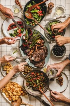 People having barbeque party dinner with meat and vegetables together Stock Photos