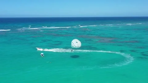 People having fun doing paraseiling in Atlantic ocean with reef and turquoise Stockbeeldmateriaal 251589769