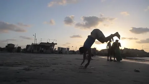 People having fun with games on the beach at sunset Stock Footage 148624716