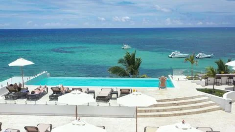 People having fun at resort with infinity swimming pool on roof poolside, t.. Stock Photos