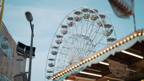 People having fun riding a ferris wheel at the amusement park on a sunny day Stock Footage 239669497