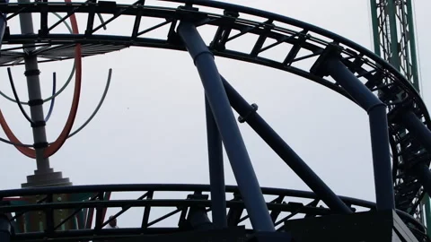 People having fun on a thrilling roller coaster ride at an amusement park Stock Footage 348003133