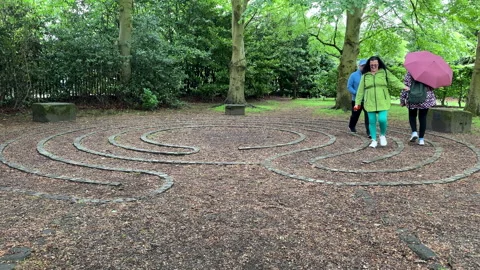 People having fun walking stone labyrinth or maze Stock Footage 337242904