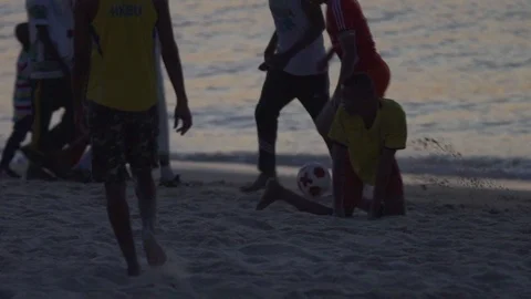 People having fun while playing soccer on beach at dusk Video stock 85776586