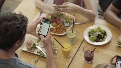 People having meal together looking at their smart phones Stock Footage 75201942