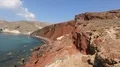 People having rest on red beach, rocks that came out after eruption of volcano HD Footage