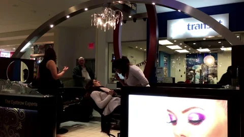 People having threading tint waxing inside Coquitlam shopping mall Stock Footage 70655656
