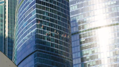 People at a height wash the windows of a skyscraper. Moscow, Russia - 12 Se.. Stock Footage 319639586