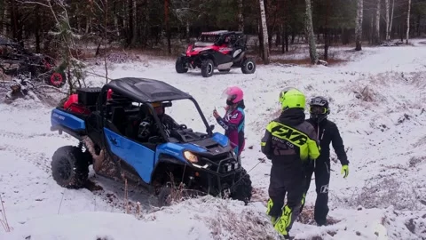 People in helmets unscrew winch on UTV Can-Am Commander and shoot video blog Stock Footage 177337393