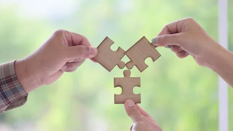 People helping in assembling puzzle, cooperation in decision making, team sup Stock Footage 200800265